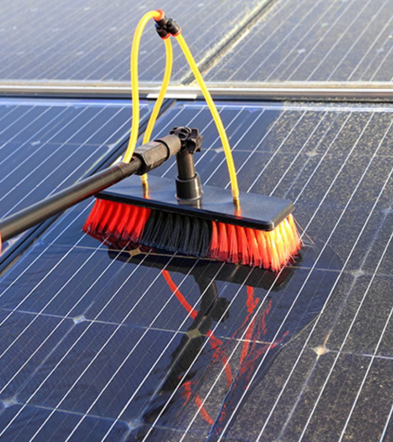 Solar Panel; A broom is utilized to maintain solar panels, illustrating the work of a solar panel cleaning service.